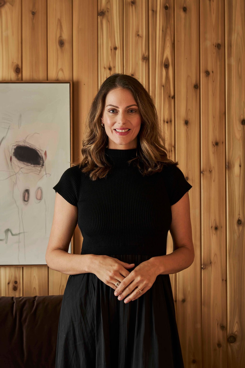 Julia Zonshine standing in front of warm wood paneling