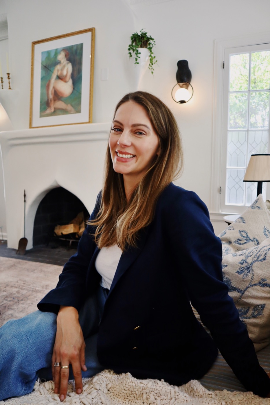 Julia Zonshine smiling beside a fireplace in a Los Angeles living room