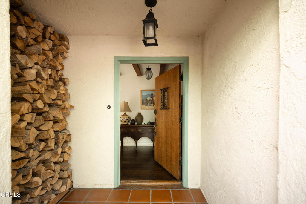 Firewood stacked floor to ceiling beside the front door at 1395 Inverness Drive