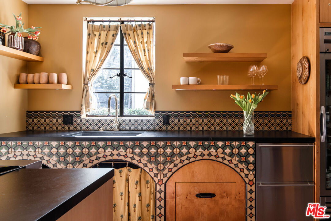 Arched kitchen with patterned tile and warm wood cabinetry at 2351 Canyon Drive