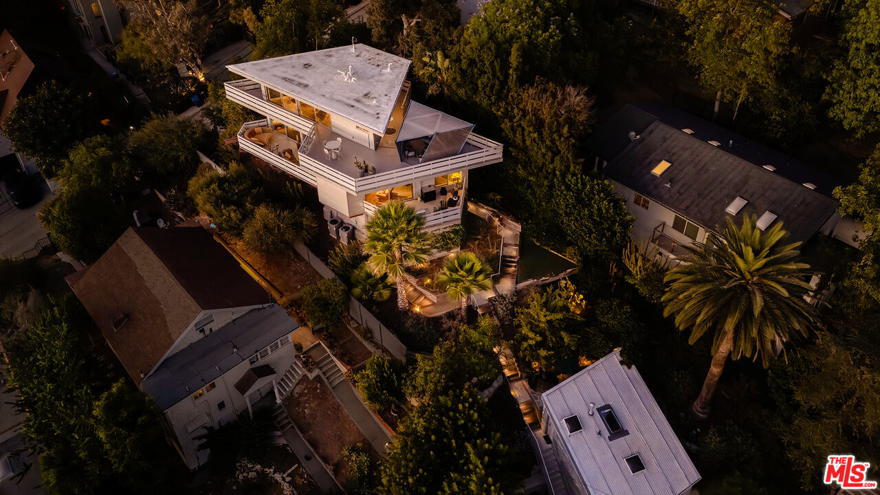 Aerial dusk view of Tattuplex's angled roofline and terraces rising above the trees at 2383 Loma Vista Pl in Silver Lake