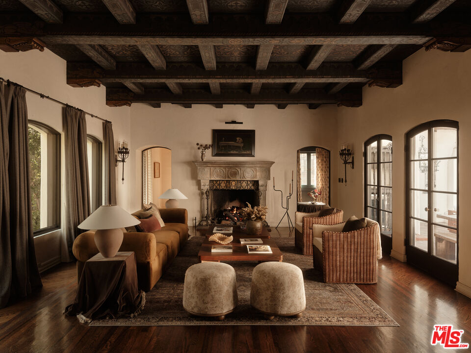 Living room with hand-painted beams and carved fireplace