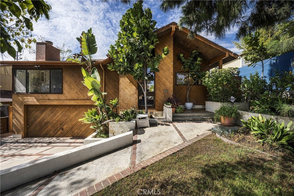 Natural wood exterior framed by greenery at 3585 Military in Westside Village