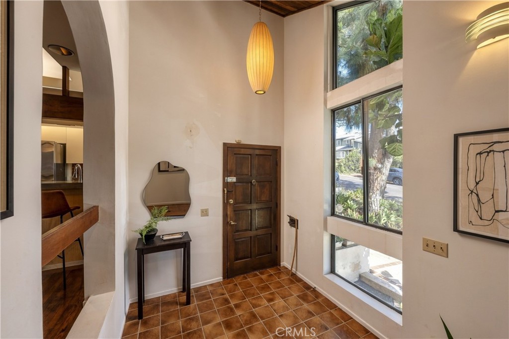 Double-height entry with a natural wood door at 3585 Military