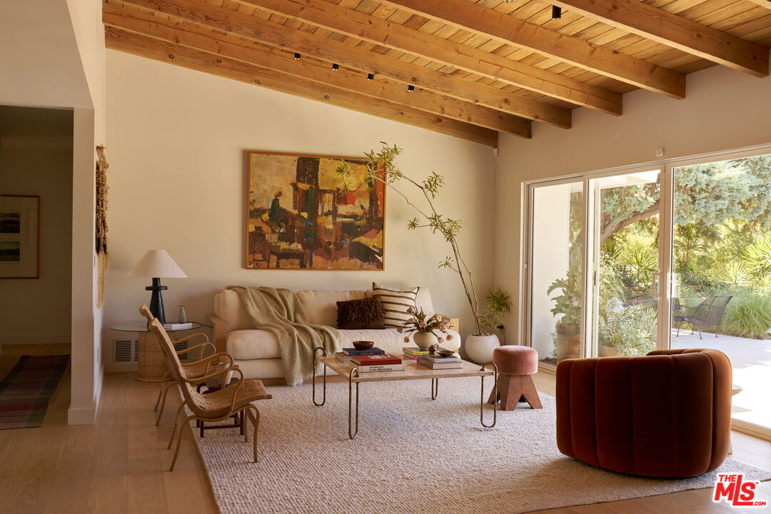 Living room with exposed wood ceilings and sliders at 4301 Manson Avenue