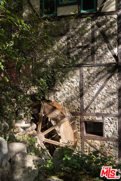 Working wooden water wheel beside the cottage