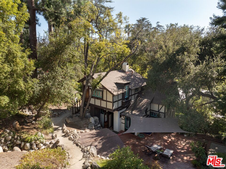Aerial view of the cottage and wooded grounds