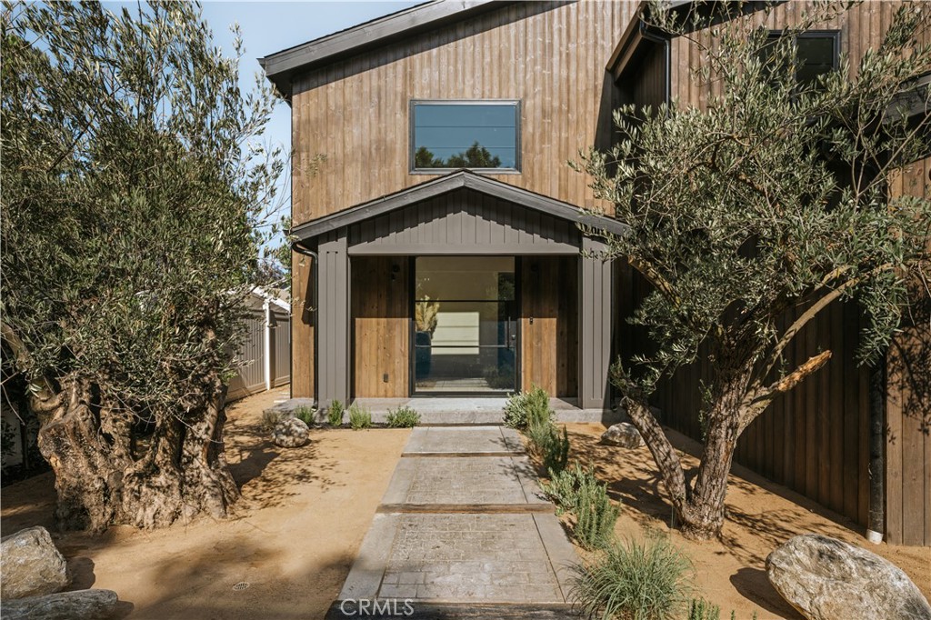 Two mature olive trees framing the entrance at 5114 Cedros Avenue