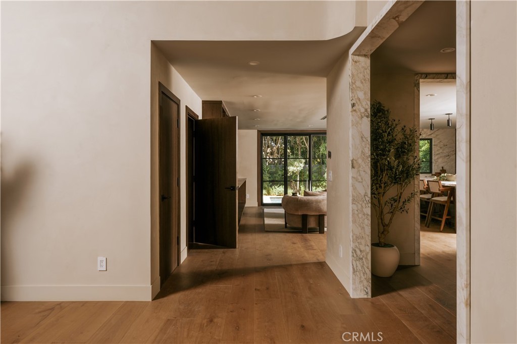 Warm modern interior with natural wood flooring and marble-framed opening