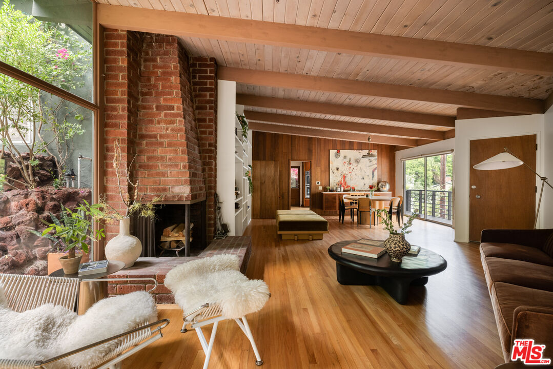 Original brick fireplace and wood-beamed living room at 5730 Cazaux Drive