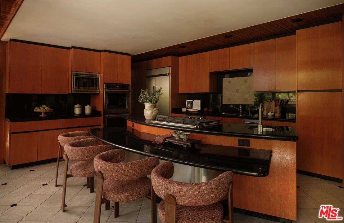 Original warm-wood kitchen with a curved black counter at 954 Hillside Terrace